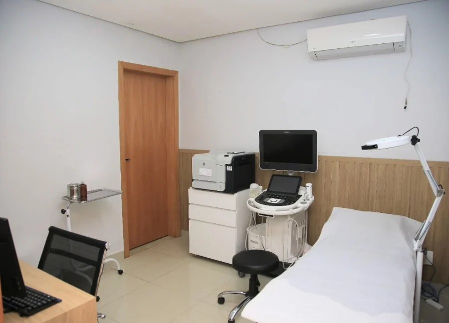 Sala de ecodoppler com o aparelho de ultrassom ao lado da maca.