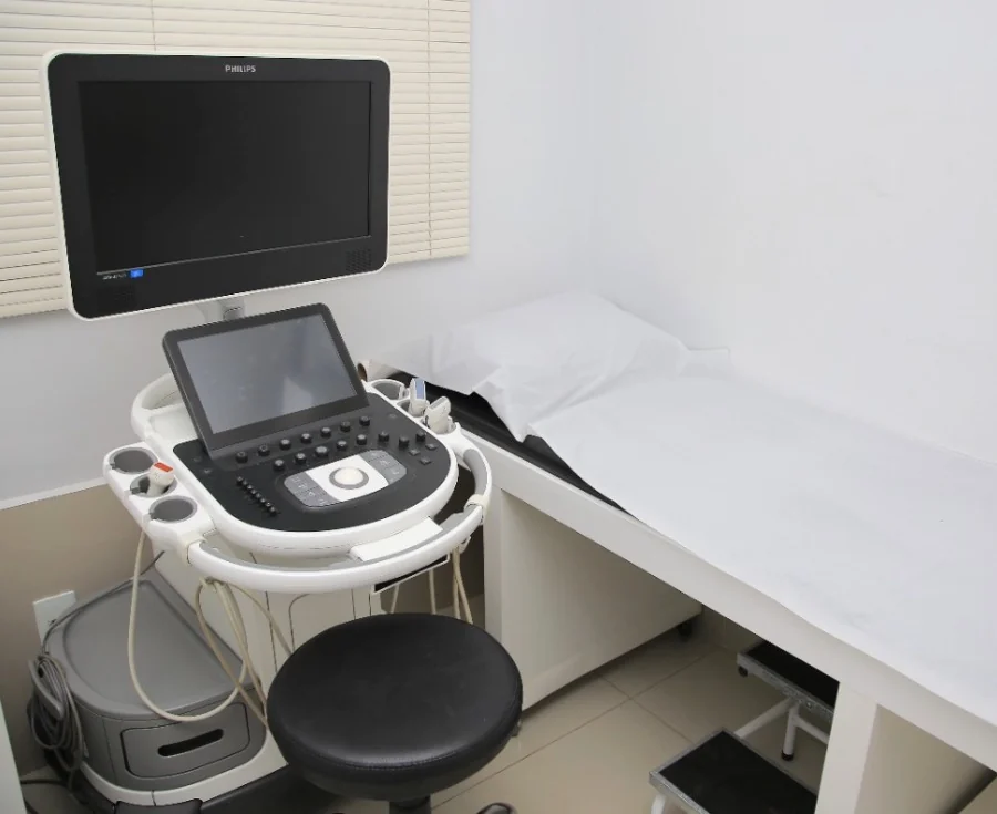 Sala de ecodoppler do Instituto de Angiologia Raja Venkata, com o aparelho de ultrassom ao lado da maca.